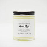 straight sided glass jar candle with black twist off metal lid and white label