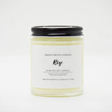 straight sided glass jar candle with black twist off metal lid and white label