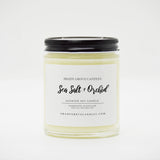 straight sided glass jar candle with black twist off metal lid and white label