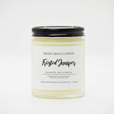 straight sided glass jar candle with black twist off metal lid and white label